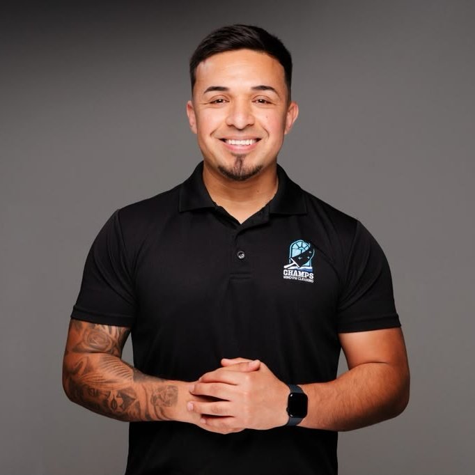 Vicente Vazquez, founder of Champs Window Cleaning, wearing a company polo shirt